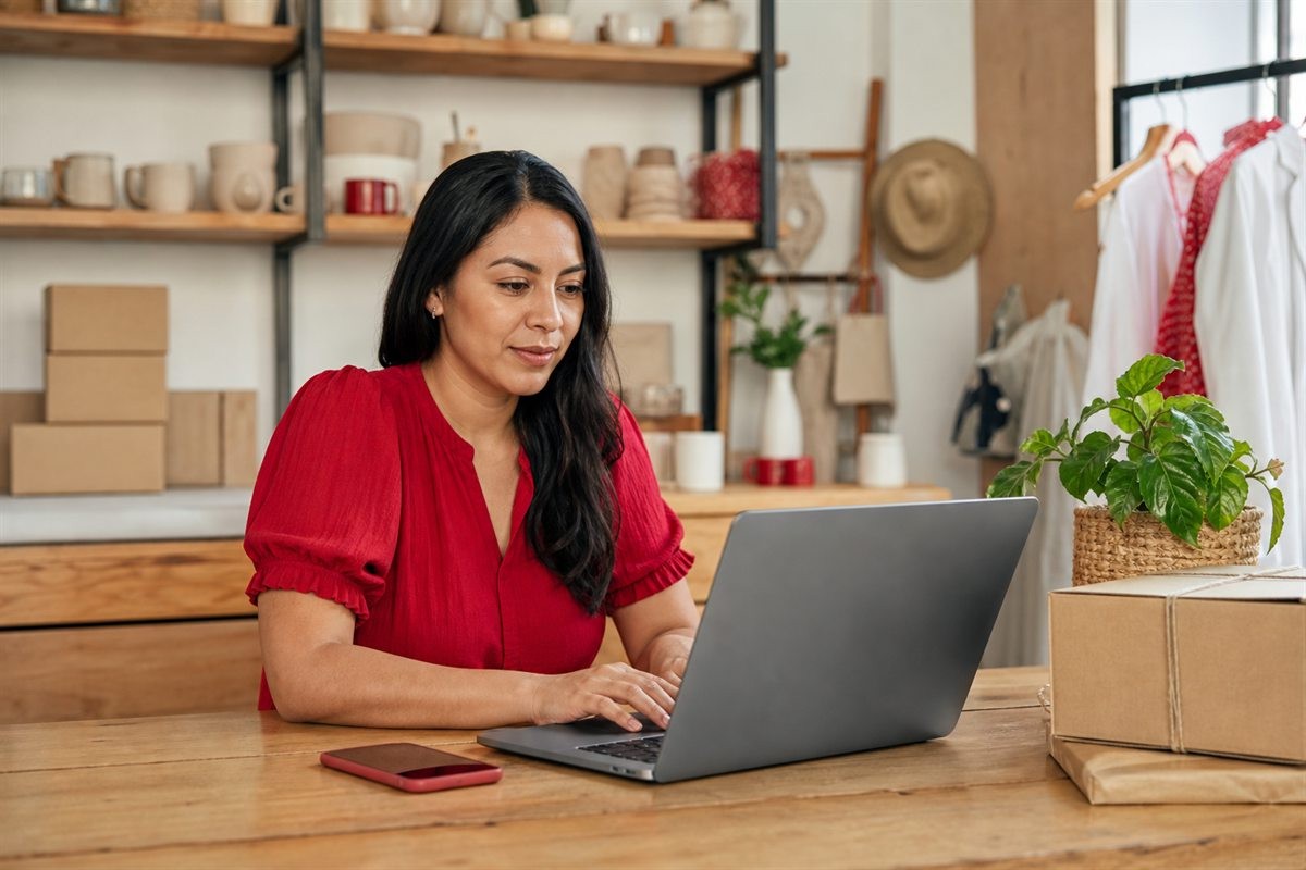 Merchant preparing orders while using MiniTiendAI on her computer